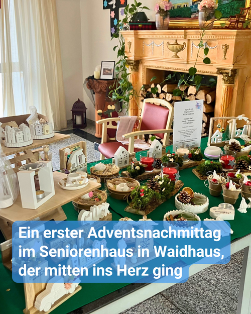 Adventszauber im Seniorenhaus Waidhaus: liebevoll gestalteter Verkaufsstand mit handgemachter Weihnachtsdekoration, Kerzenarrangements, Miniaturhäuschen und Naturmaterialien, aufgebaut im festlich geschmückten Aufenthaltsraum mit Kamin und winterlicher Atmosphäre.